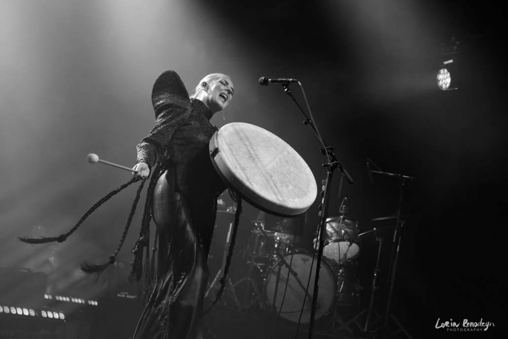Black & white photo of Eivør holding a big pale framedrum and drumstick