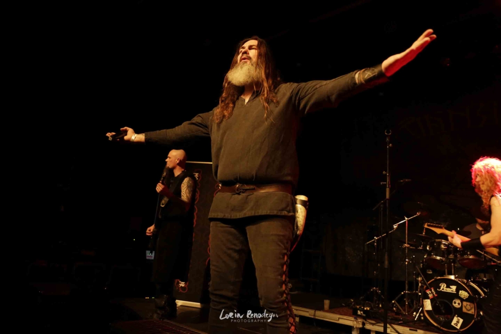 Vansind frontman J Asgaard with arms spread wide toward the audience during a concert